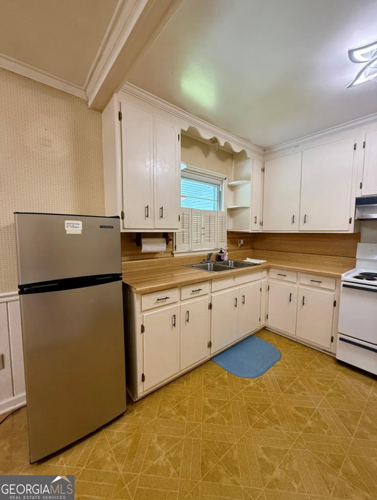 93 Arnall Boulevard Blakely, GA 39823 - Photo 16 of 43 a kitchen with granite countertop a refrigerator sink stove and white cabinets