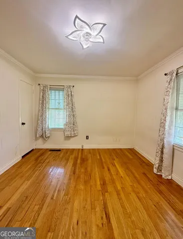 a view of empty room with wooden floor