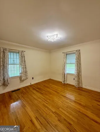 a view of empty room with wooden floor