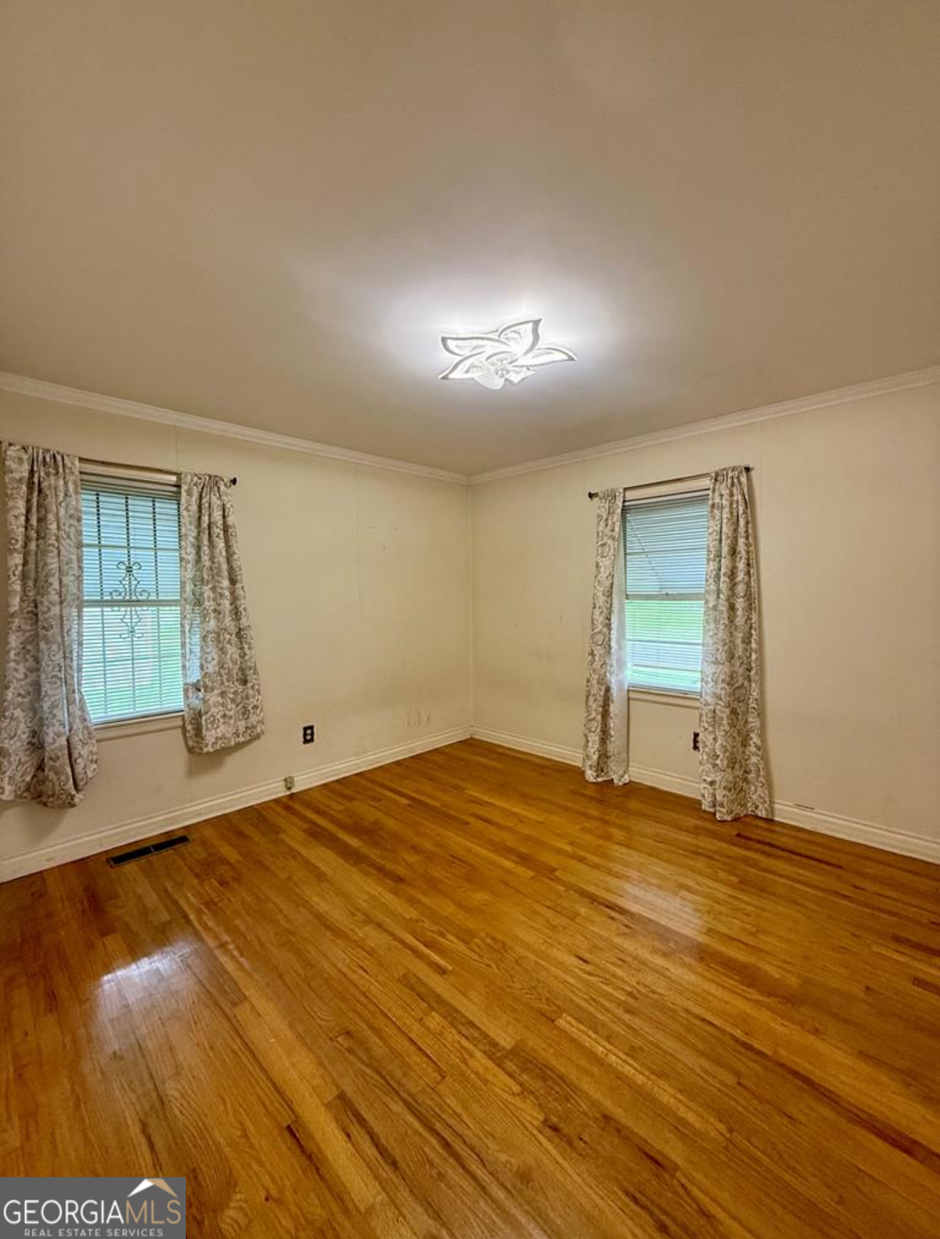 93 Arnall Boulevard Blakely, GA 39823 - Photo 31 of 43 a view of an empty room with wooden floor and a window