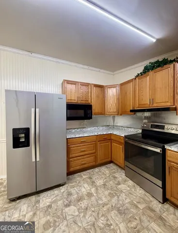 a kitchen with stainless steel appliances granite countertop a refrigerator sink and stove