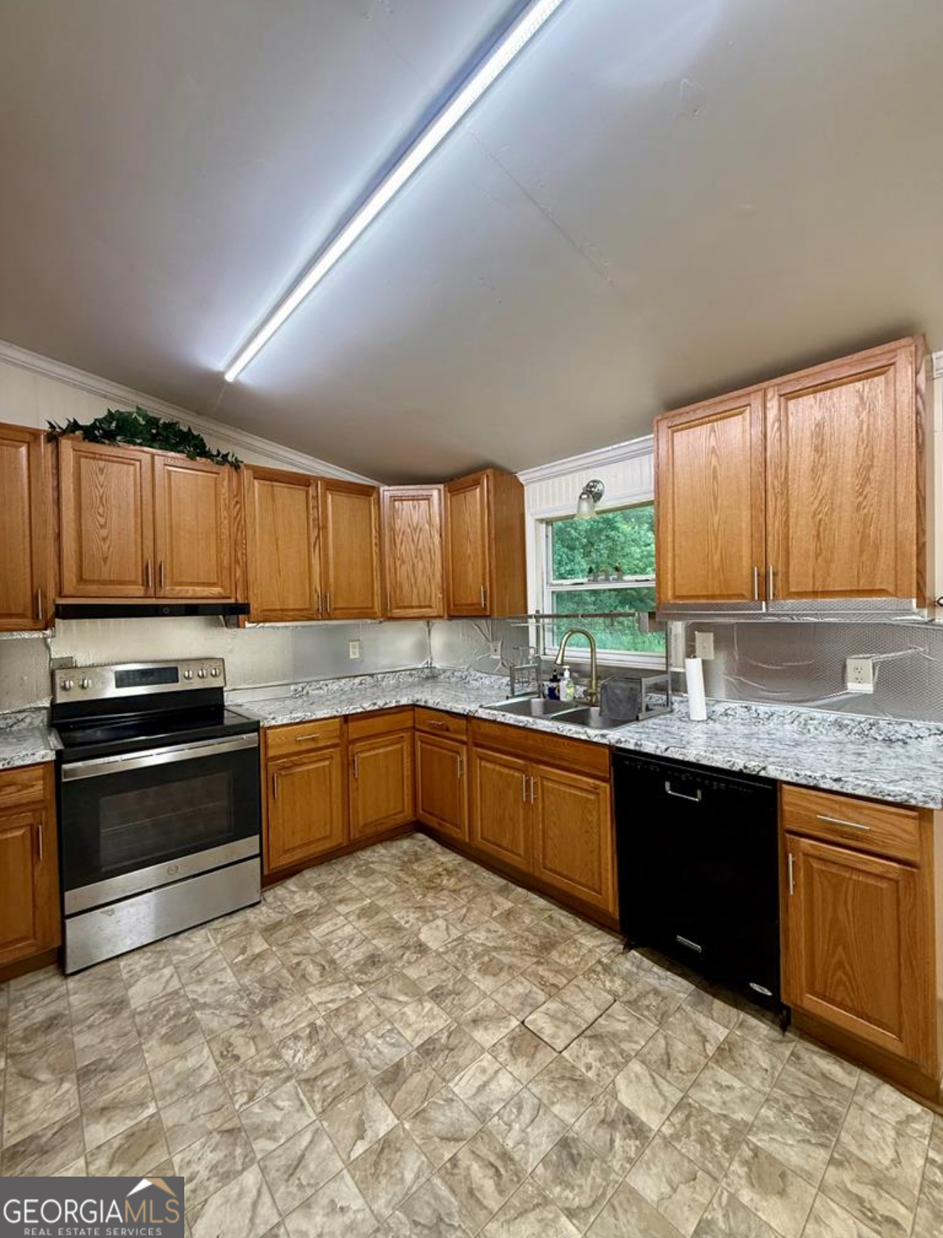 93 Arnall Boulevard Blakely, GA 39823 - Photo 5 of 43 a kitchen with stainless steel appliances granite countertop a stove sink and cabinets