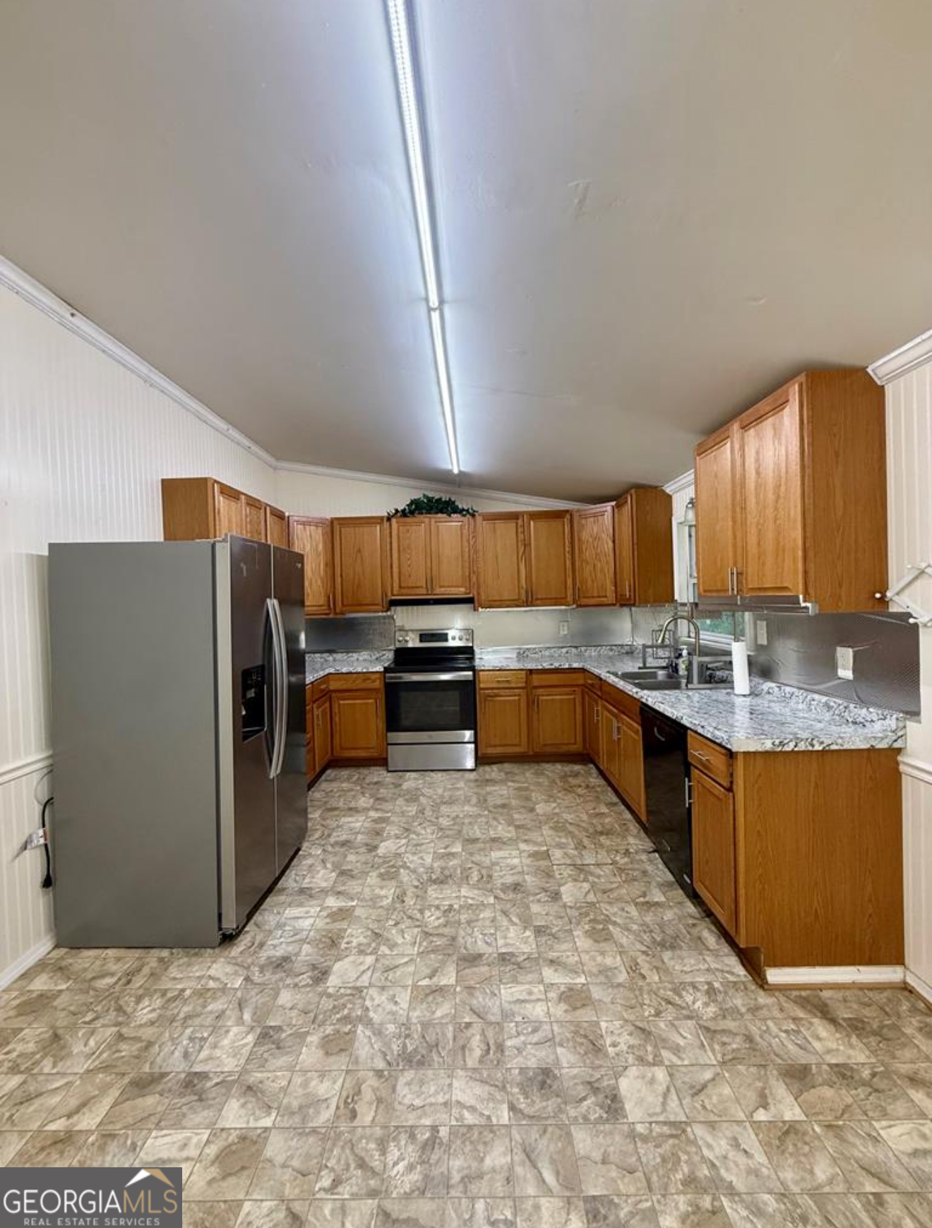 93 Arnall Boulevard Blakely, GA 39823 - Photo 7 of 43 a large kitchen with kitchen island granite countertop a refrigerator and a sink