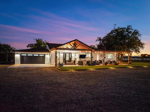 a front view of a house with patio and garden
