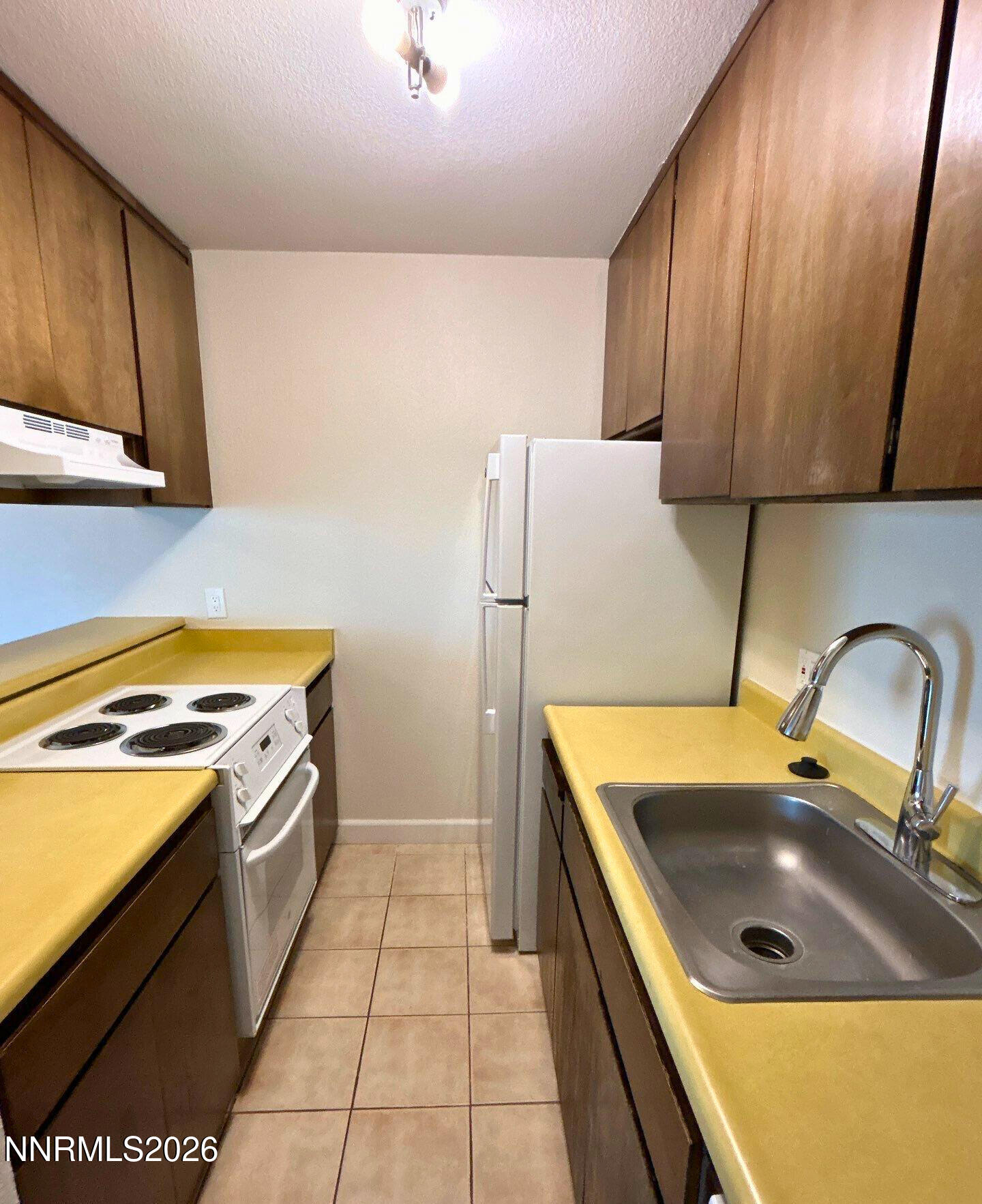 2450 Lymbery Street, Unit 305 Reno, NV 89509 - Photo 8 of 13 a kitchen with a refrigerator and a sink