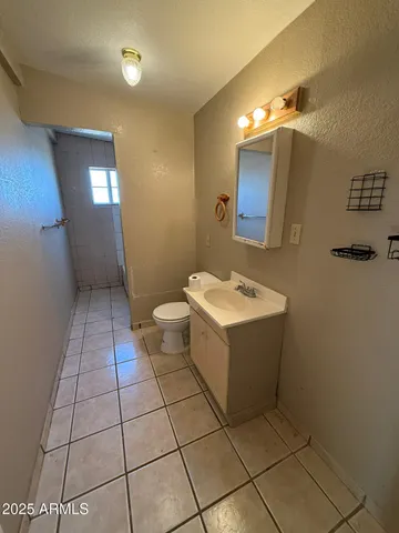 a bathroom with a toilet a sink a mirror and vanity