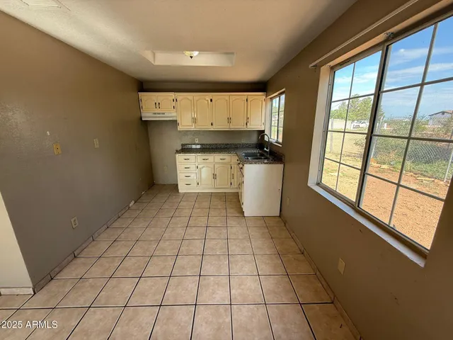 a kitchen with granite countertop white cabinets and white appliances