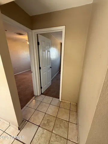 an empty room with a chandelier fan and window