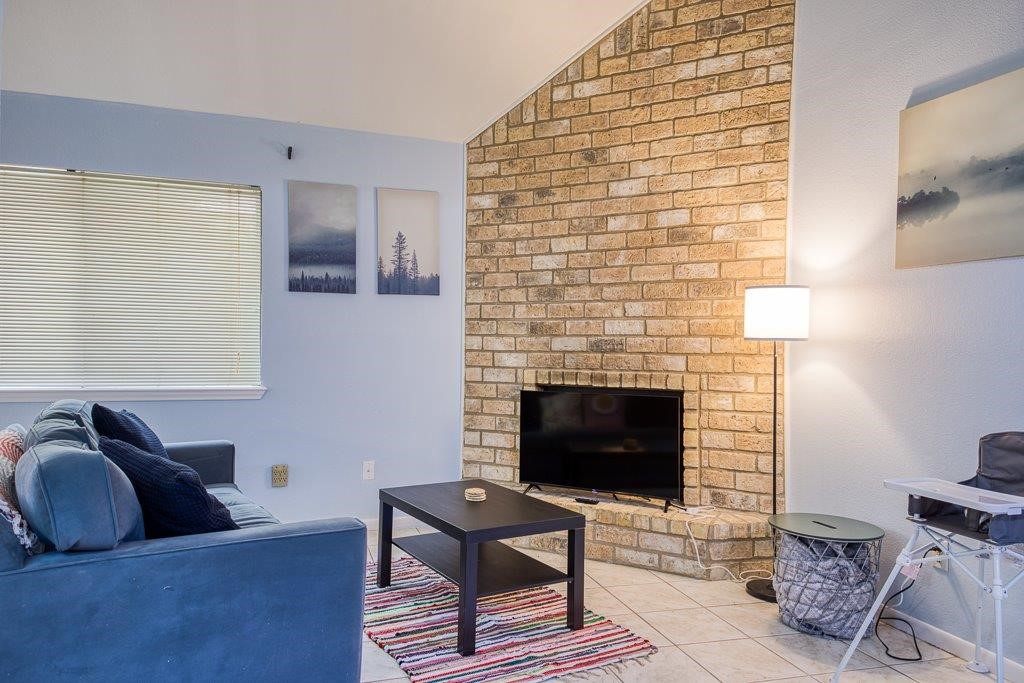 906 St Christopher Street Corpus Christi, TX 78418 - Photo 13 of 40 a living room with furniture a flat screen tv and a fireplace