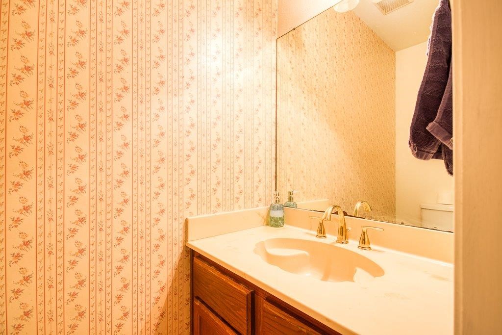 906 St Christopher Street Corpus Christi, TX 78418 - Photo 28 of 40 a bathroom with a granite countertop sink and a mirror