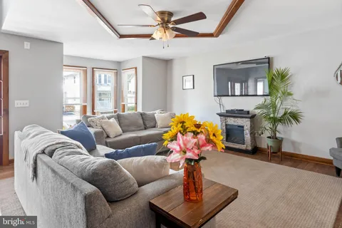 a living room with furniture flowers and a window