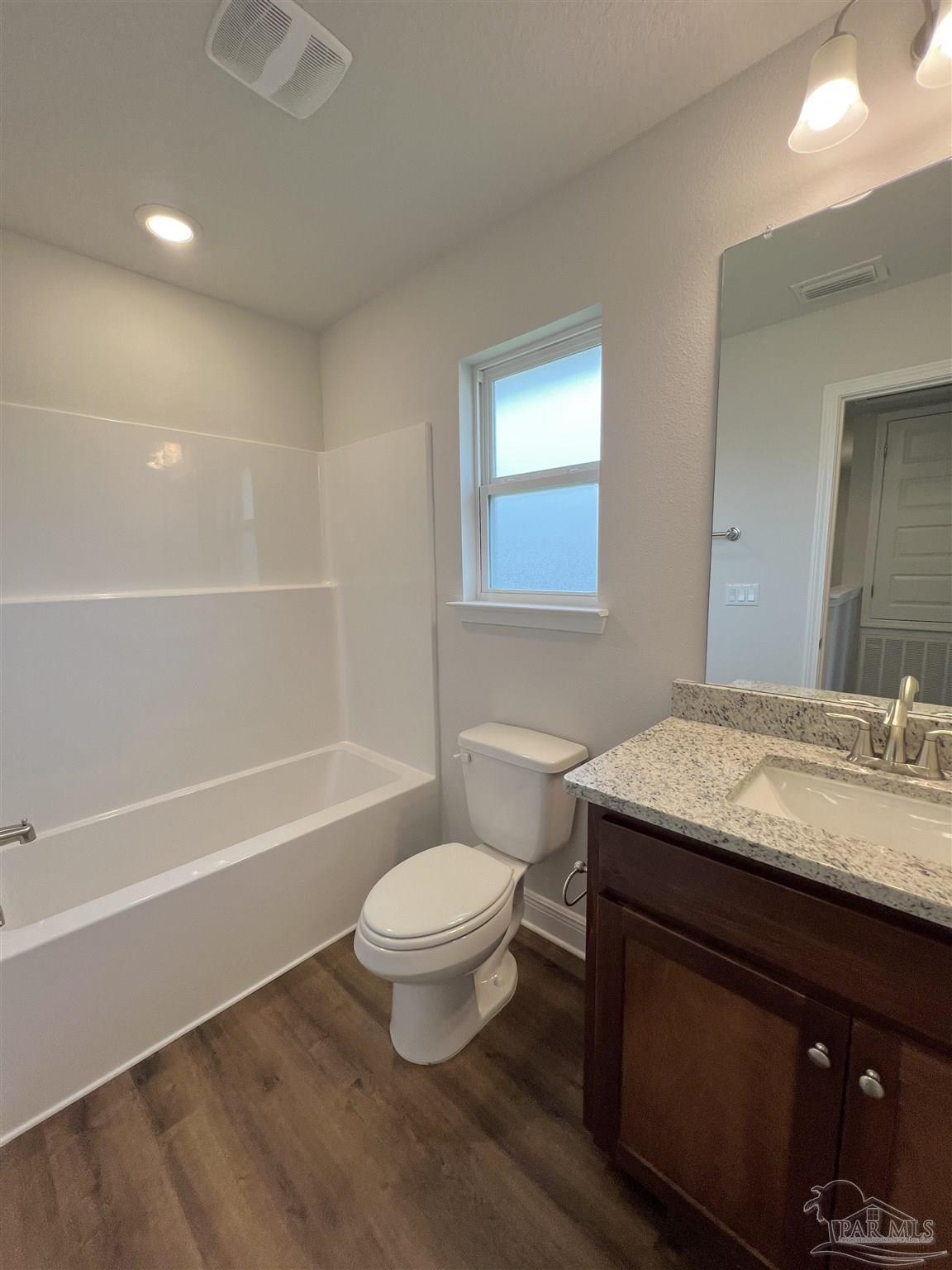 928 Rustling Pnes Road, Unit 16B Cantonment, FL 32533 - Photo 9 of 15 a bathroom with a granite countertop sink a toilet a mirror and bathtub