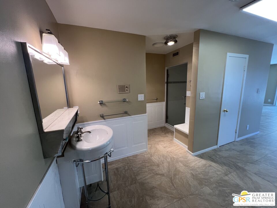 Undisclosed Address Yucca Valley, CA 92284 - Photo 25 of 46 a spacious bathroom with a granite countertop sink a toilet a mirror and vanity