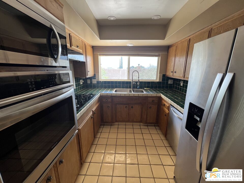 Undisclosed Address Yucca Valley, CA 92284 - Photo 7 of 46 a kitchen with a sink a stove top oven and refrigerator