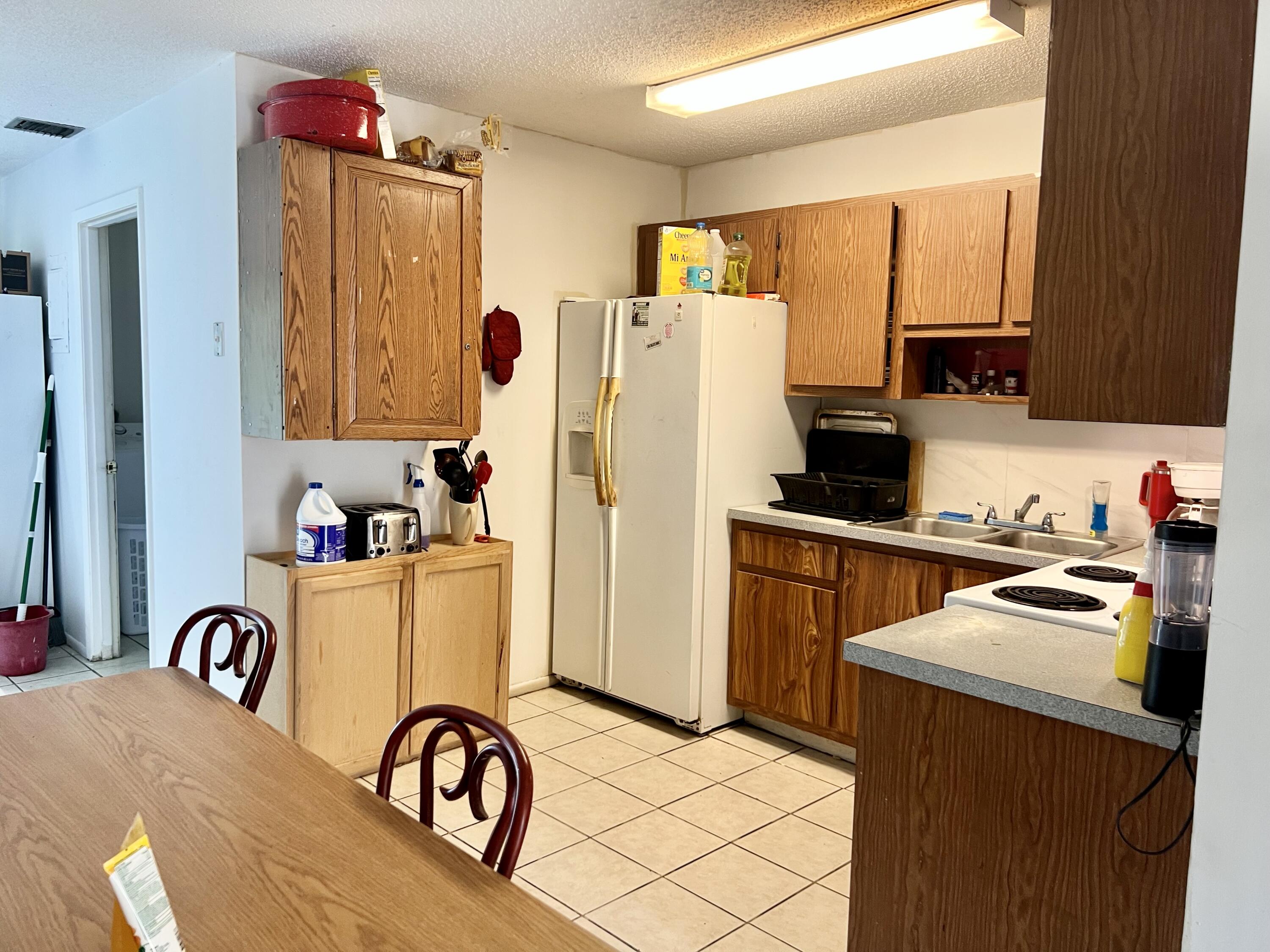 2621 Southeast Clayton Street Stuart, FL 34997 - Photo 12 of 40 a kitchen with a refrigerator a stove top oven a sink and dishwasher
