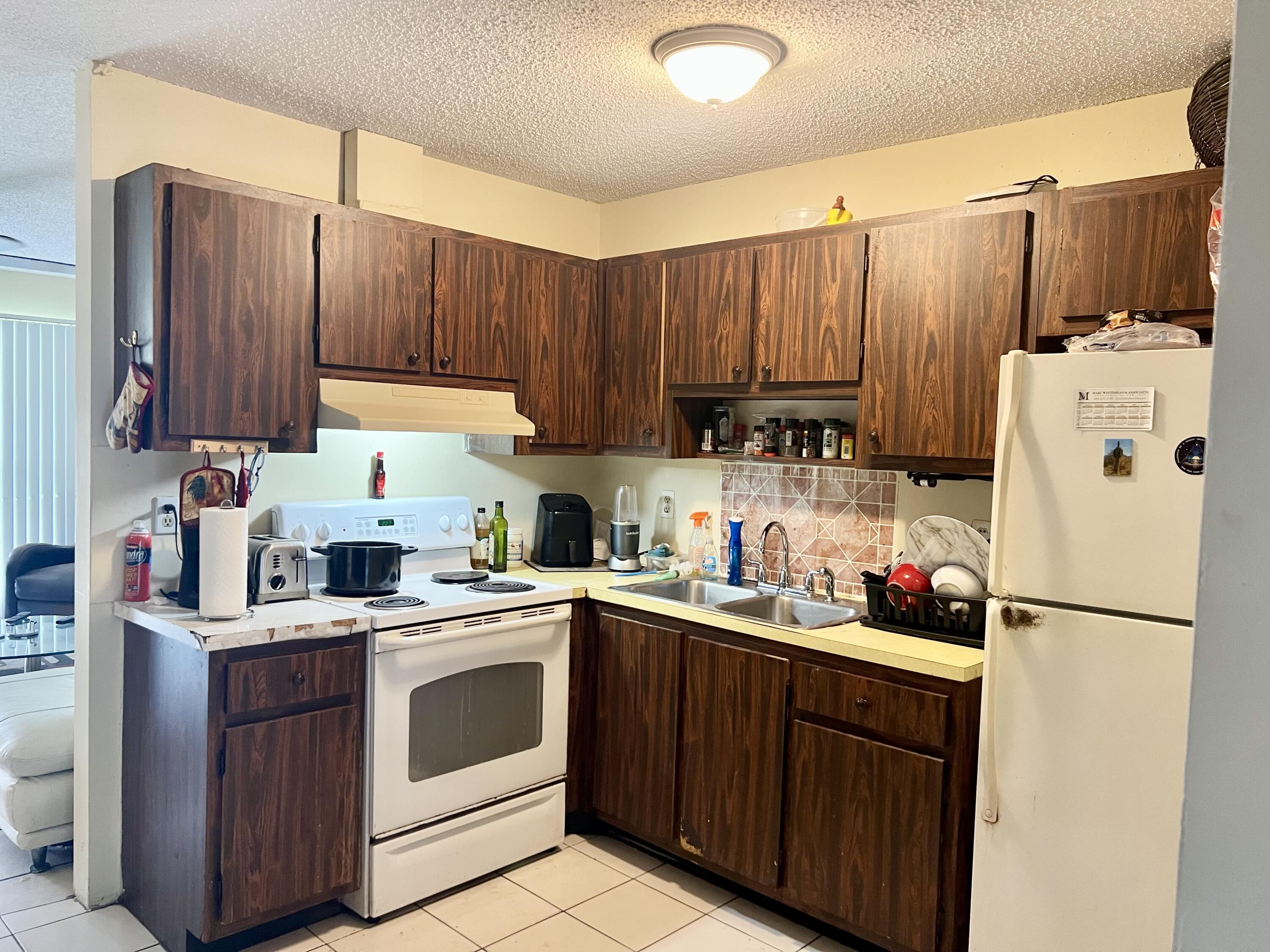 2621 Southeast Clayton Street Stuart, FL 34997 - Photo 15 of 40 a kitchen with a sink a refrigerator and cabinets