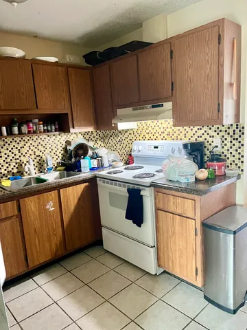 a kitchen with stainless steel appliances granite countertop a sink stove and cabinets