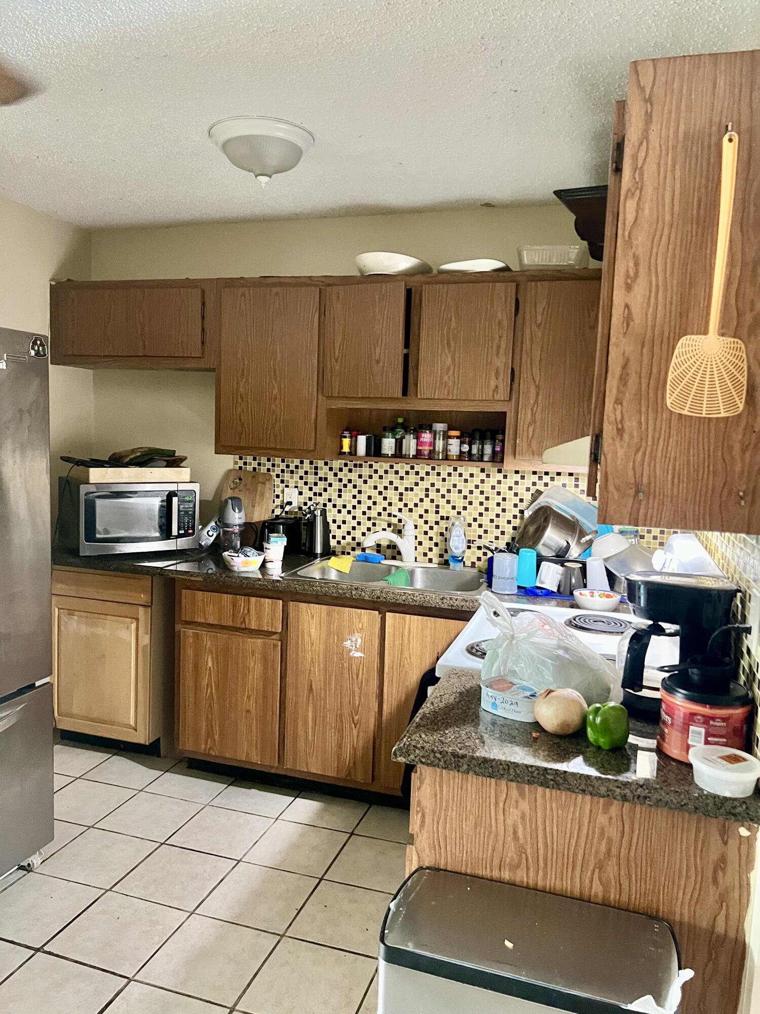2621 Southeast Clayton Street Stuart, FL 34997 - Photo 26 of 40 a kitchen with stainless steel appliances granite countertop a sink dishwasher stove and cabinets