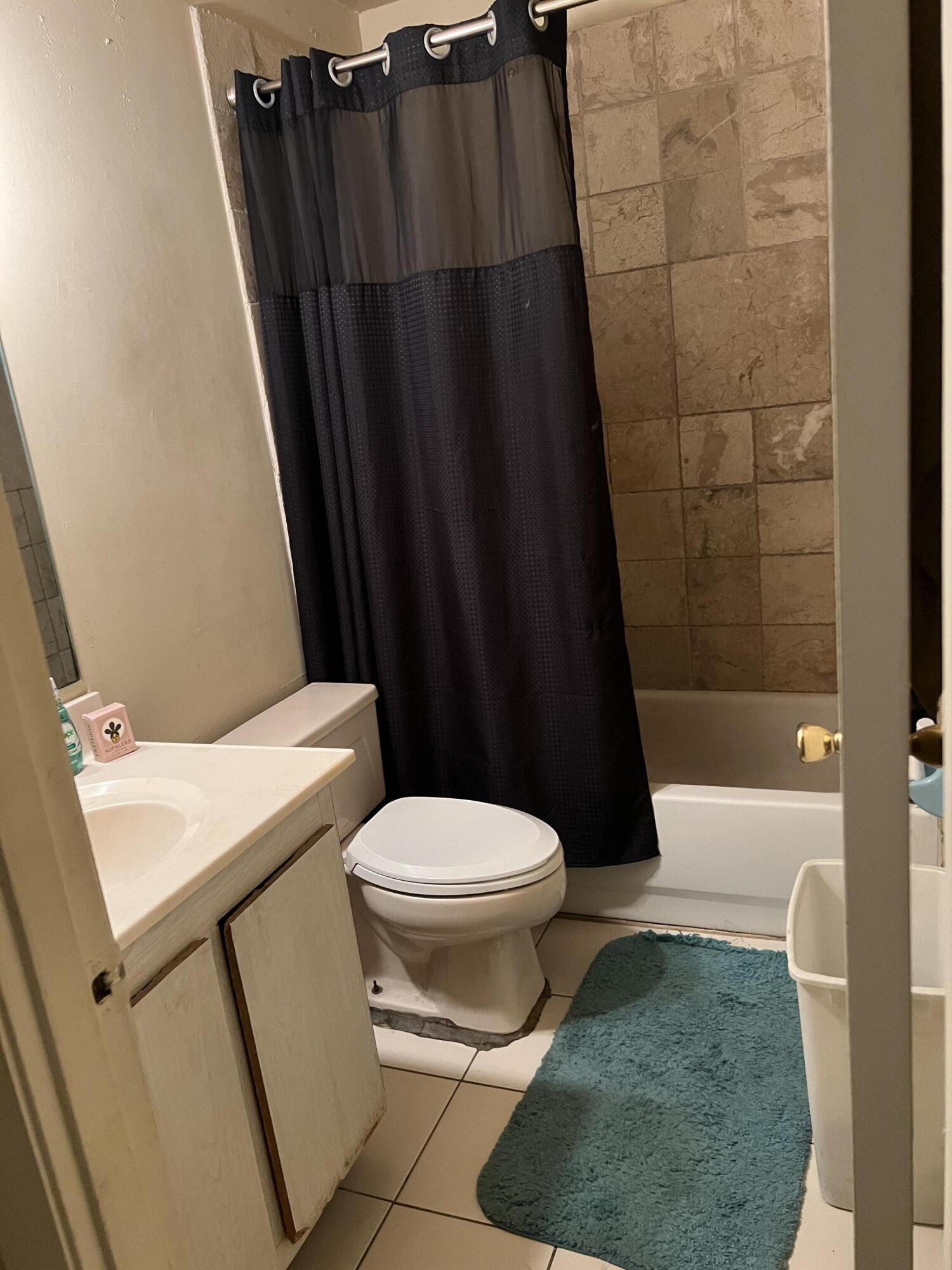 2621 Southeast Clayton Street Stuart, FL 34997 - Photo 35 of 40 a white toilet sitting next to a shower curtain