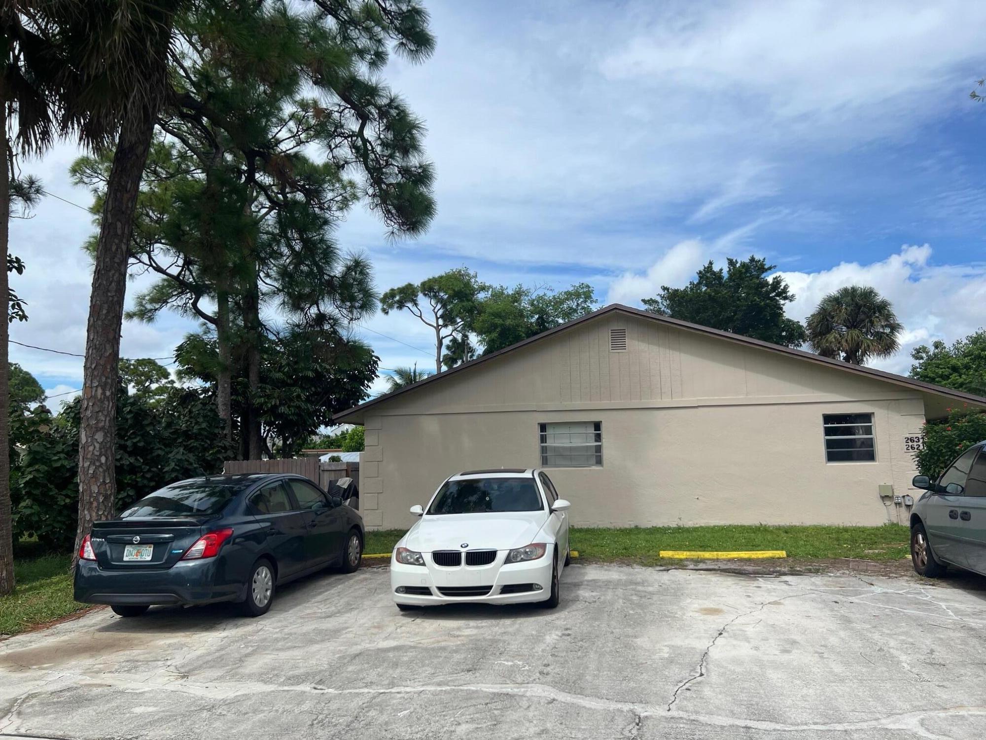 2621 Southeast Clayton Street Stuart, FL 34997 - Photo 5 of 40 a car parked in front of a white house