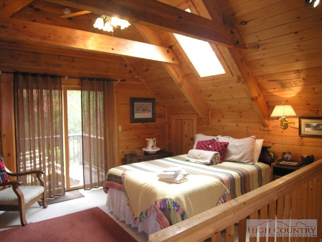 236 Frog Hollar Road Deep Gap, NC 28618 - Photo 9 of 23 a bedroom with a bed and wooden floor