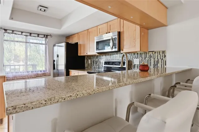 a kitchen with stainless steel appliances granite countertop a sink and a microwave