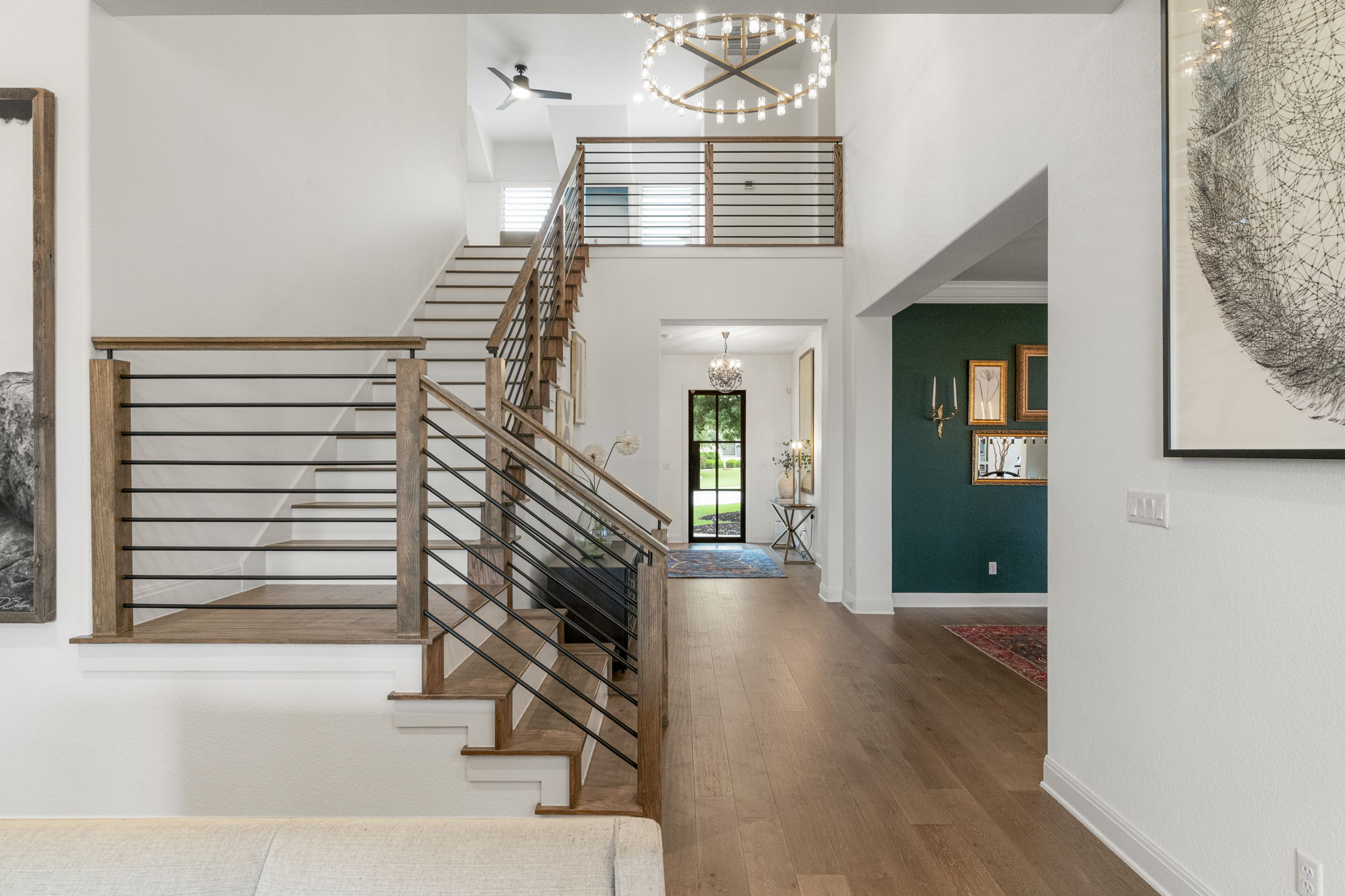 288 Hazy Hills Loop Dripping Springs, TX 78620 - Photo 3 of 40 A light-filled staircase with modern horizontal railing detail, creating a strong architectural moment upon entry.