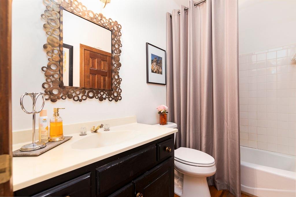 135 Lazy Laurel Chase Roswell, GA 30076 - Photo 16 of 64 a bathroom with a sink a toilet and shower curtain