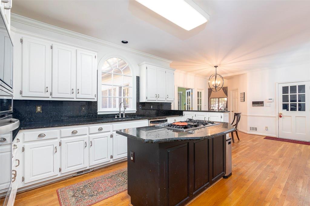 135 Lazy Laurel Chase Roswell, GA 30076 - Photo 20 of 64 a kitchen with stainless steel appliances granite countertop a stove a sink and white cabinets