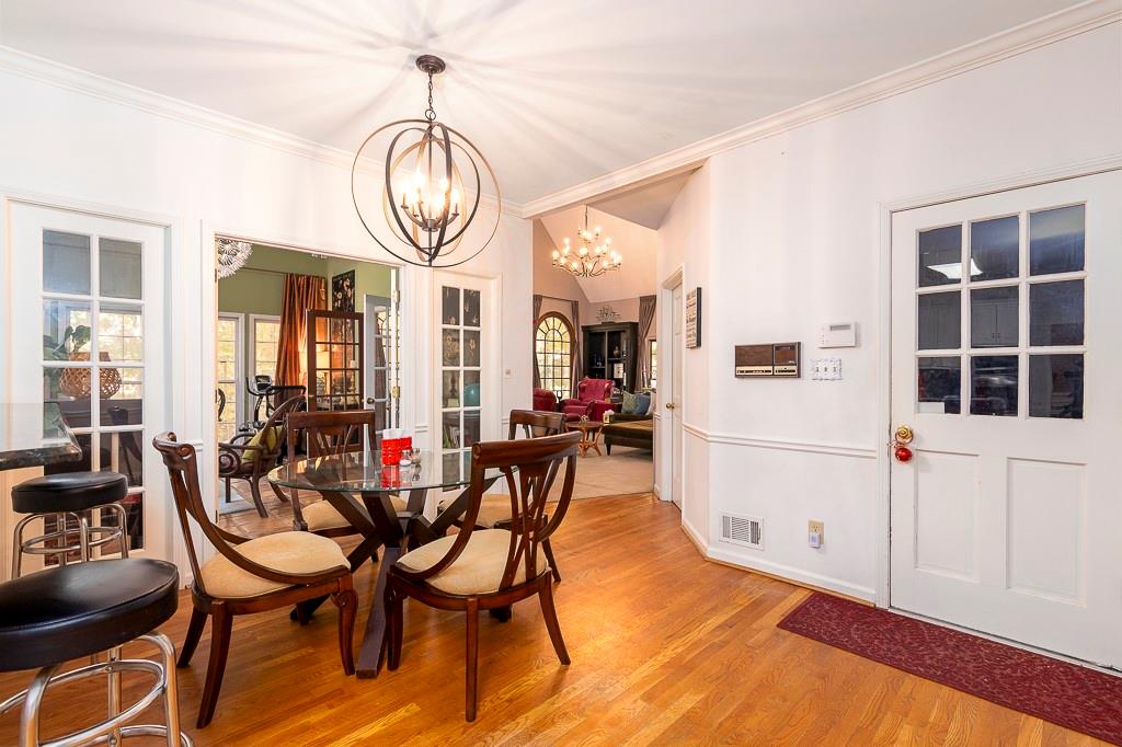 135 Lazy Laurel Chase Roswell, GA 30076 - Photo 24 of 64 a view of dining room and livingroom with furniture wooden floor a chandelier