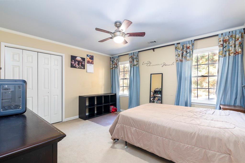 135 Lazy Laurel Chase Roswell, GA 30076 - Photo 35 of 64 a spacious bedroom with a large bed a chandelier and dresser
