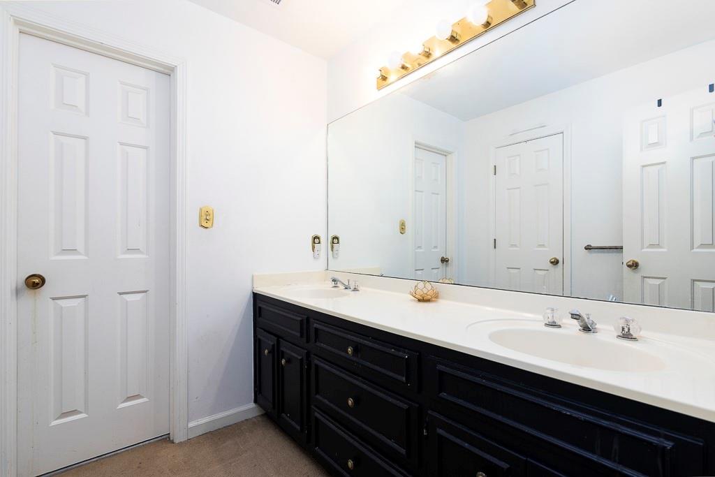 135 Lazy Laurel Chase Roswell, GA 30076 - Photo 36 of 64 a bathroom with a double vanity sink and a mirror