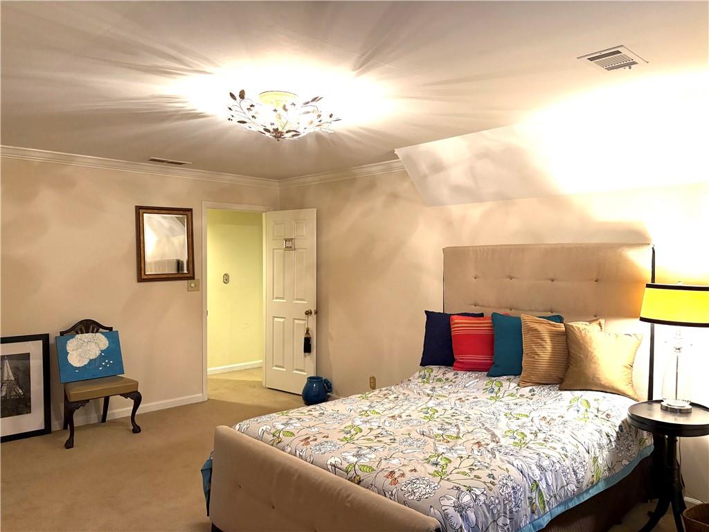 135 Lazy Laurel Chase Roswell, GA 30076 - Photo 38 of 64 a bedroom with a bed and a chandelier