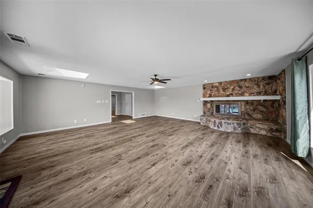 a big room with wooden floor and window