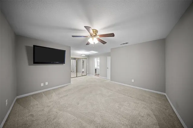 en empty room with ceiling fan and window
