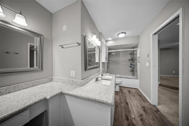 a spacious bathroom with a granite countertop sink mirror and shower