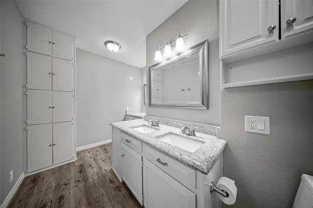 a bathroom with a sink vanity granite and toilet