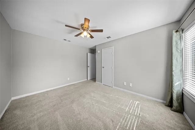 a view of room with a ceiling fan and window