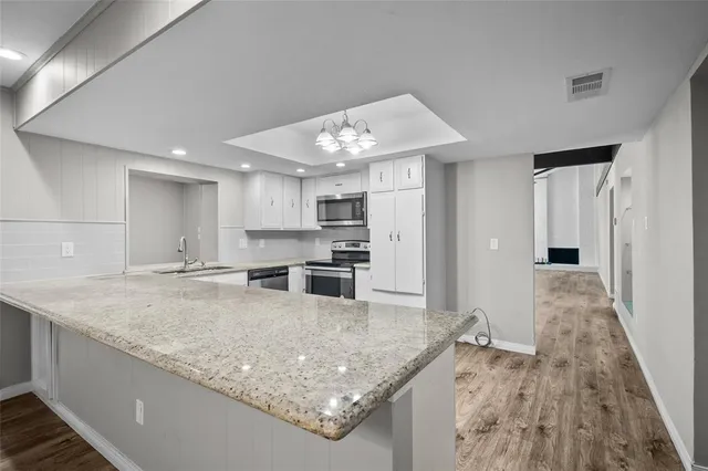 a kitchen with stainless steel appliances granite countertop a sink oven and refrigerator