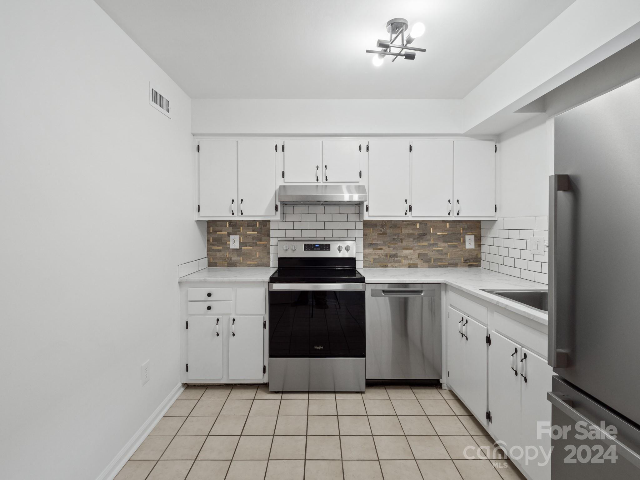 6306 Old Pineville Road, Unit B Charlotte, NC 28217 - Photo 6 of 16 a kitchen with white cabinets and appliances