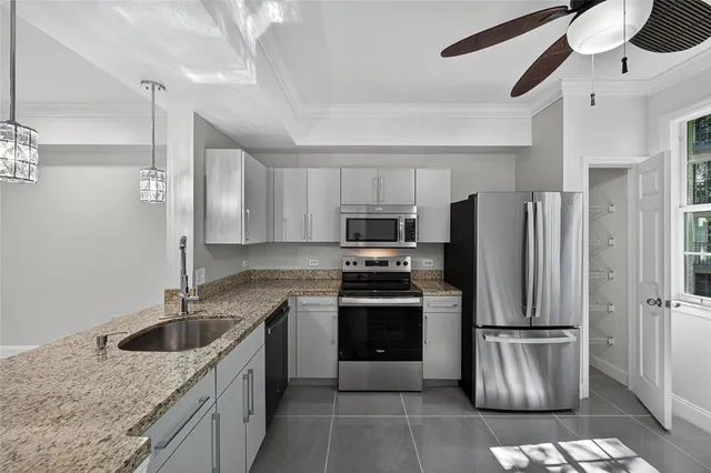 a kitchen with stainless steel appliances granite countertop a refrigerator a stove a sink and a refrigerator