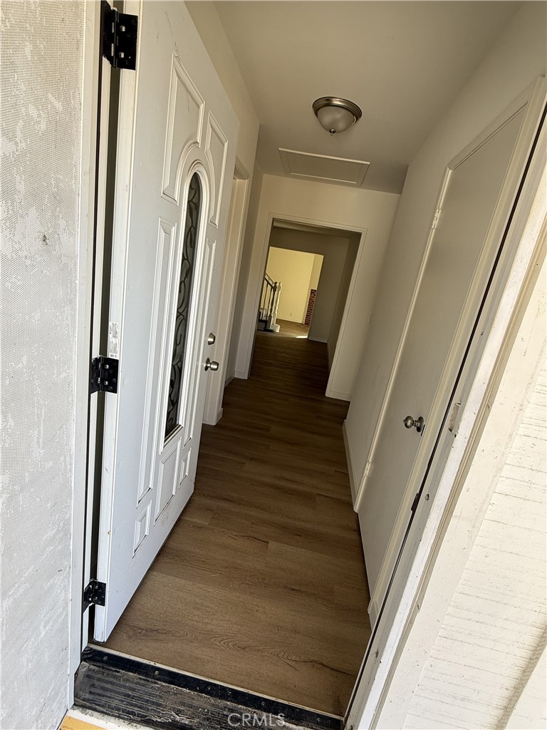 a view of a hallway with wooden floor and staircase