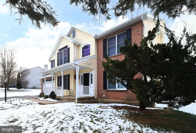 a front view of a house with a yard covered in snow