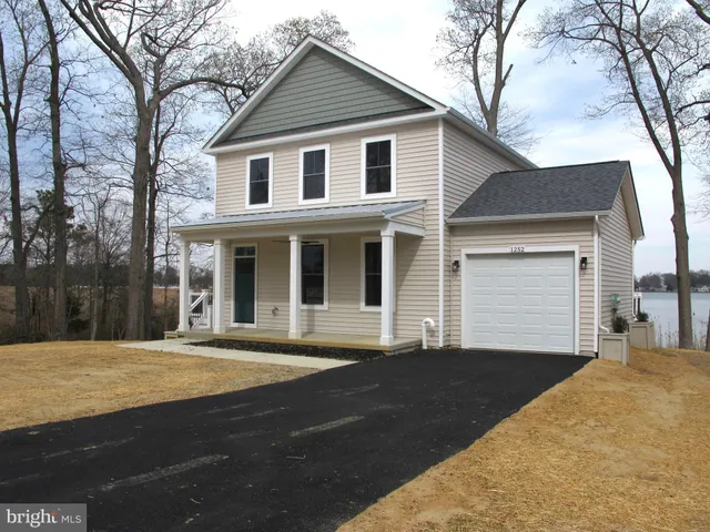 a view of a white house with a large tree
