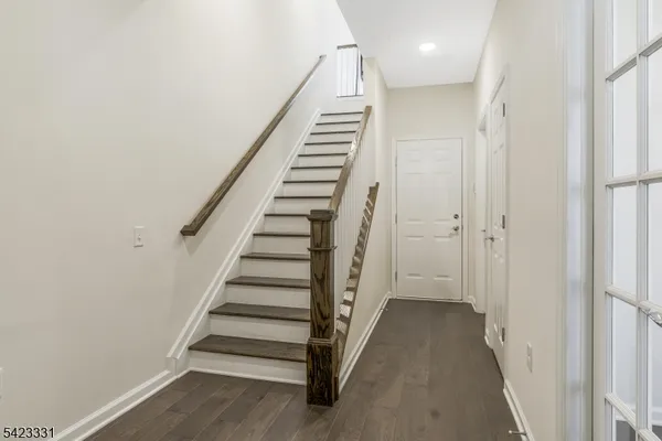 a view of a hallway with stairs and wooden floor