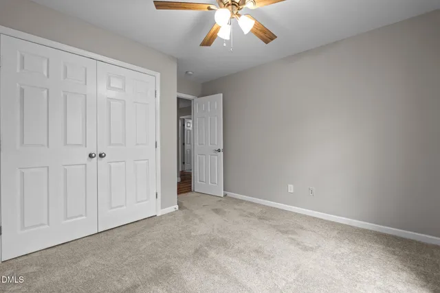 a view of an empty room and chandelier fan