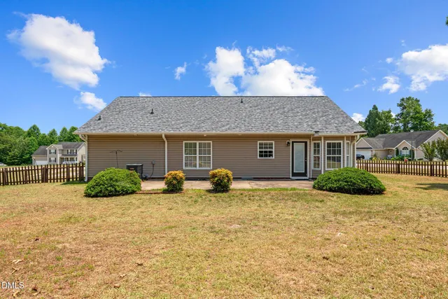 a view of a house with a yard and potted plants