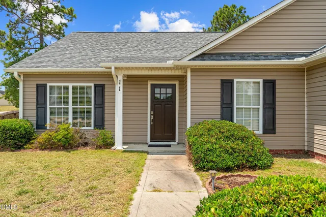 an aerial view of a house with a yard and large tree
