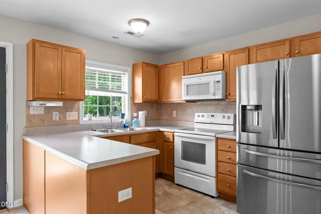 a kitchen with stainless steel appliances granite countertop a refrigerator sink and stove
