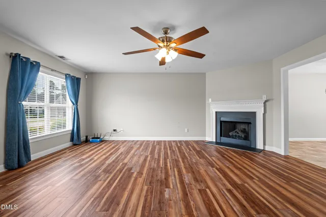 a view of empty room with wooden floor and fireplace